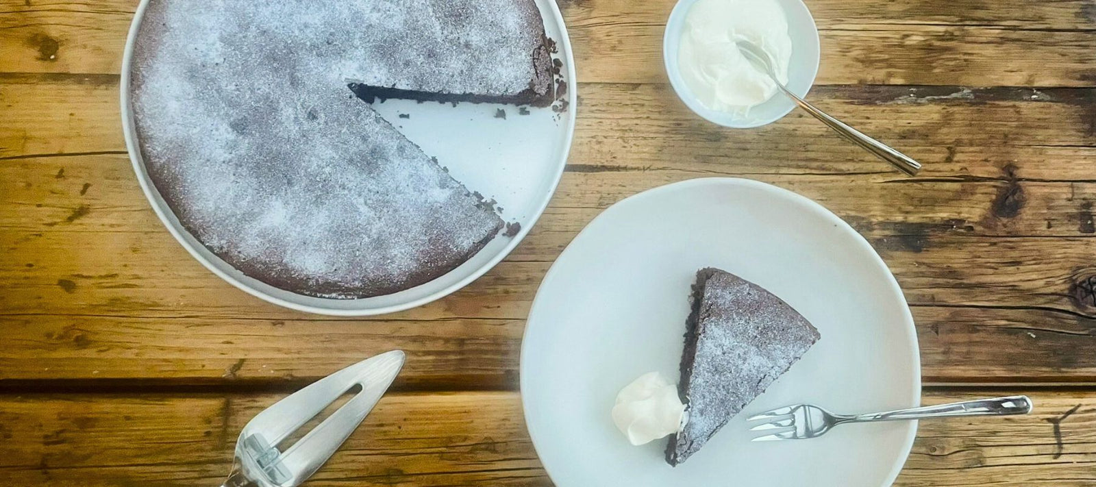 Torta Caprese mit einem Stück Kuchen angerichtet auf Teller
